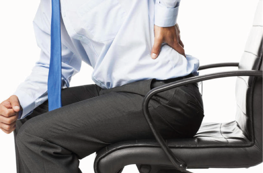 persona sentada en una silla tomándose la zona lumbar